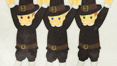 A Boy Wearing A Pilgrim Costume And Holding Corn